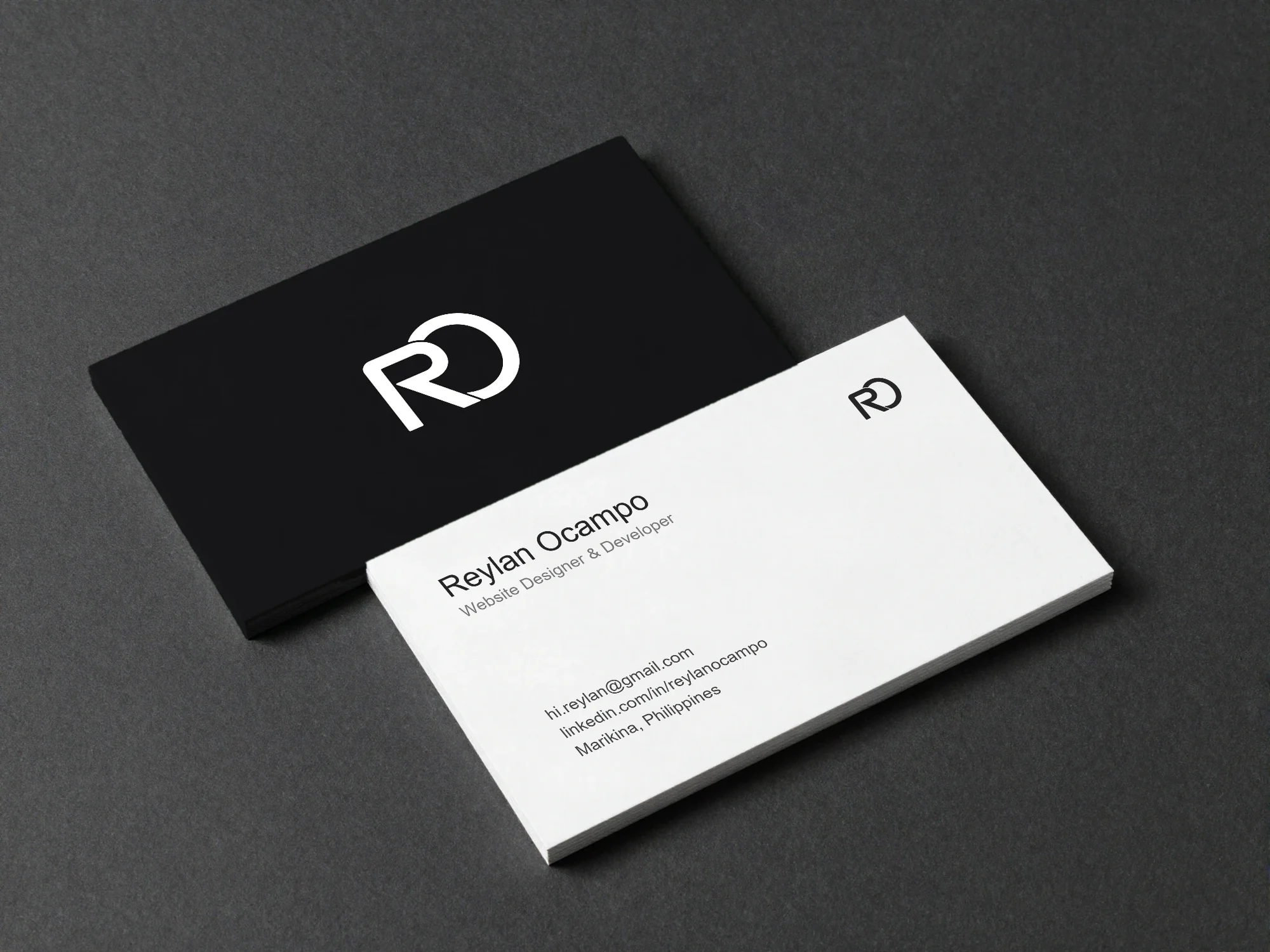 Black and white RO business cards on a charcoal surface
